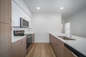 A modern kitchen with wooden cabinets and stainless steel appliances.